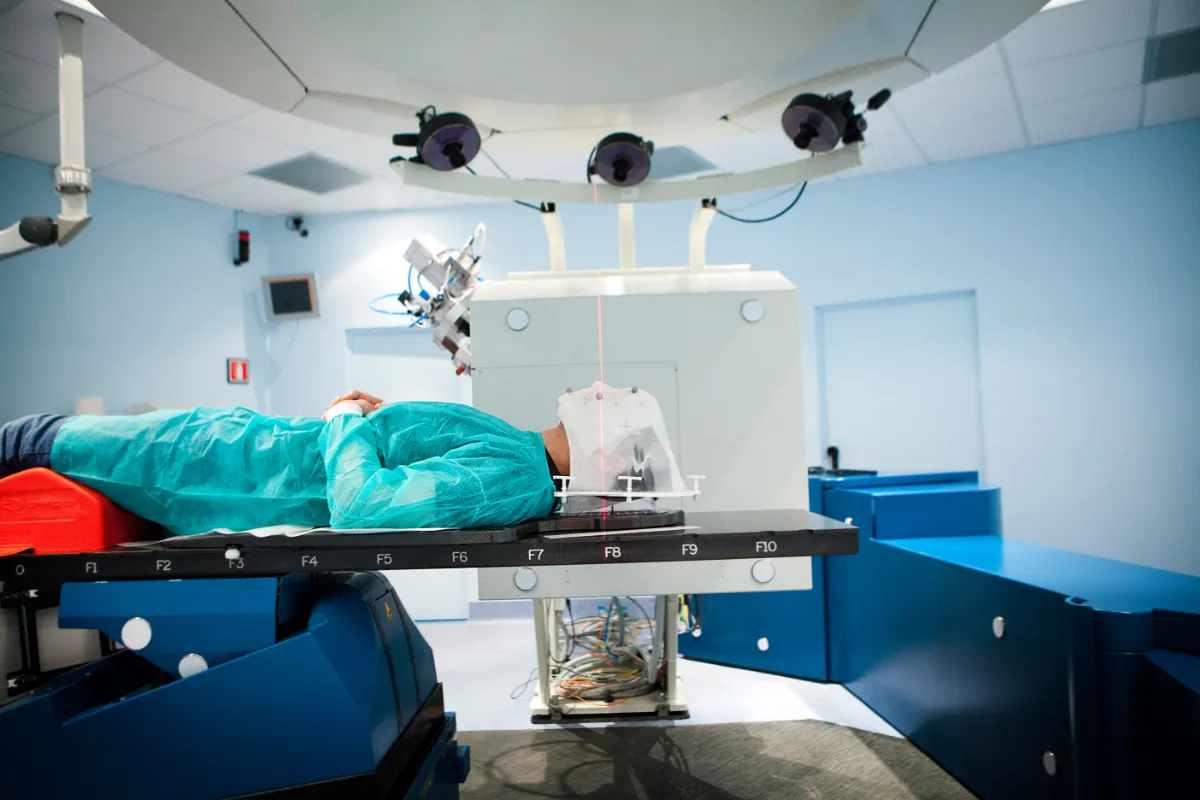 Patient sur une table de radiologue, en cours d'examen - Oncocare